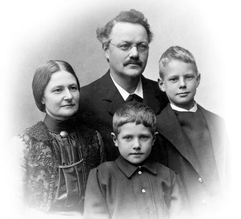 Porträtt i studio runt sekelskiftet 1900 av mor, far och två söner. Foto. 